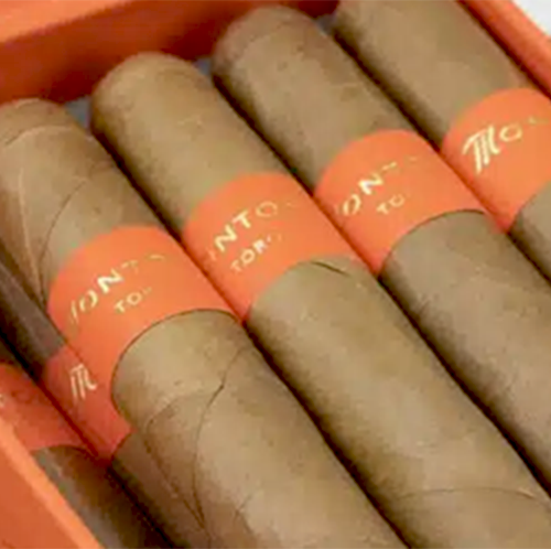 Box of Montosa Toro Natural 5 7/8x50 cigars, elegantly presented in an electric orange box. Each hand-rolled cigar features an Ecuadorian Connecticut Shade wrapper, a Mexican San Andres binder, and a blend of Dominican Criollo, Piloto, and Indonesian Java fillers. This premium Dominican cigar offers a delicately spicy, creamy smoking experience, crafted in the fertile Cibao Valley.