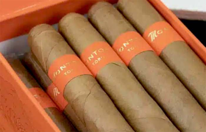 Box of Montosa Toro Natural 5 7/8x50 cigars, elegantly presented in an electric orange box. Each hand-rolled cigar features an Ecuadorian Connecticut Shade wrapper, a Mexican San Andres binder, and a blend of Dominican Criollo, Piloto, and Indonesian Java fillers. This premium Dominican cigar offers a delicately spicy, creamy smoking experience, crafted in the fertile Cibao Valley.